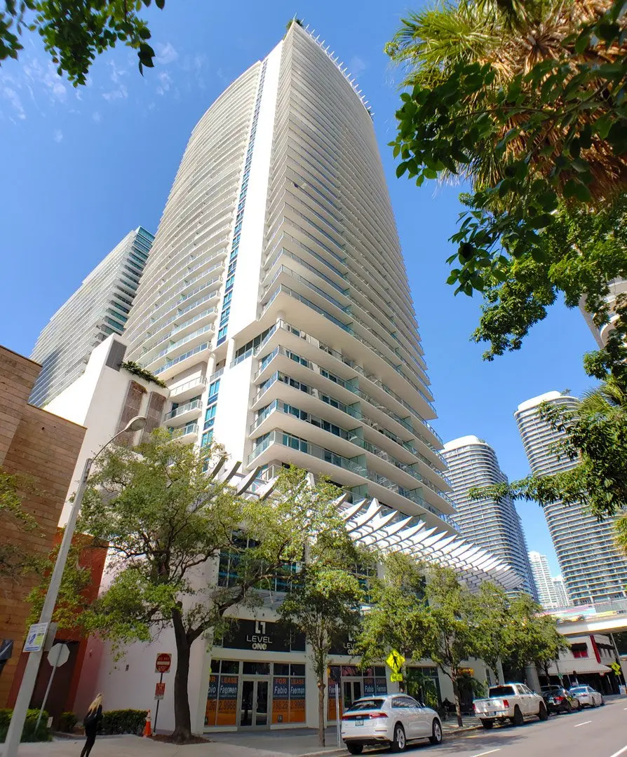 1100 Millecento tower set against the Miami skyline with surrounding greenery.