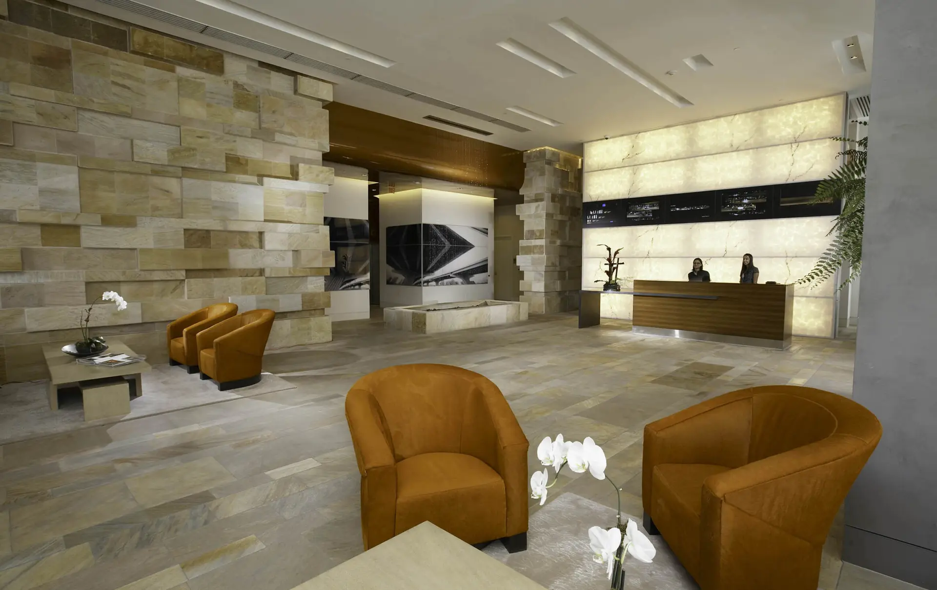 Luxurious lobby with orange seating and modern desk at 500 Brickell West.