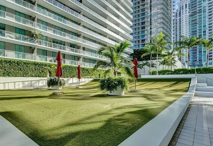Green courtyard at Axis on Brickell South with tall buildings in Miami