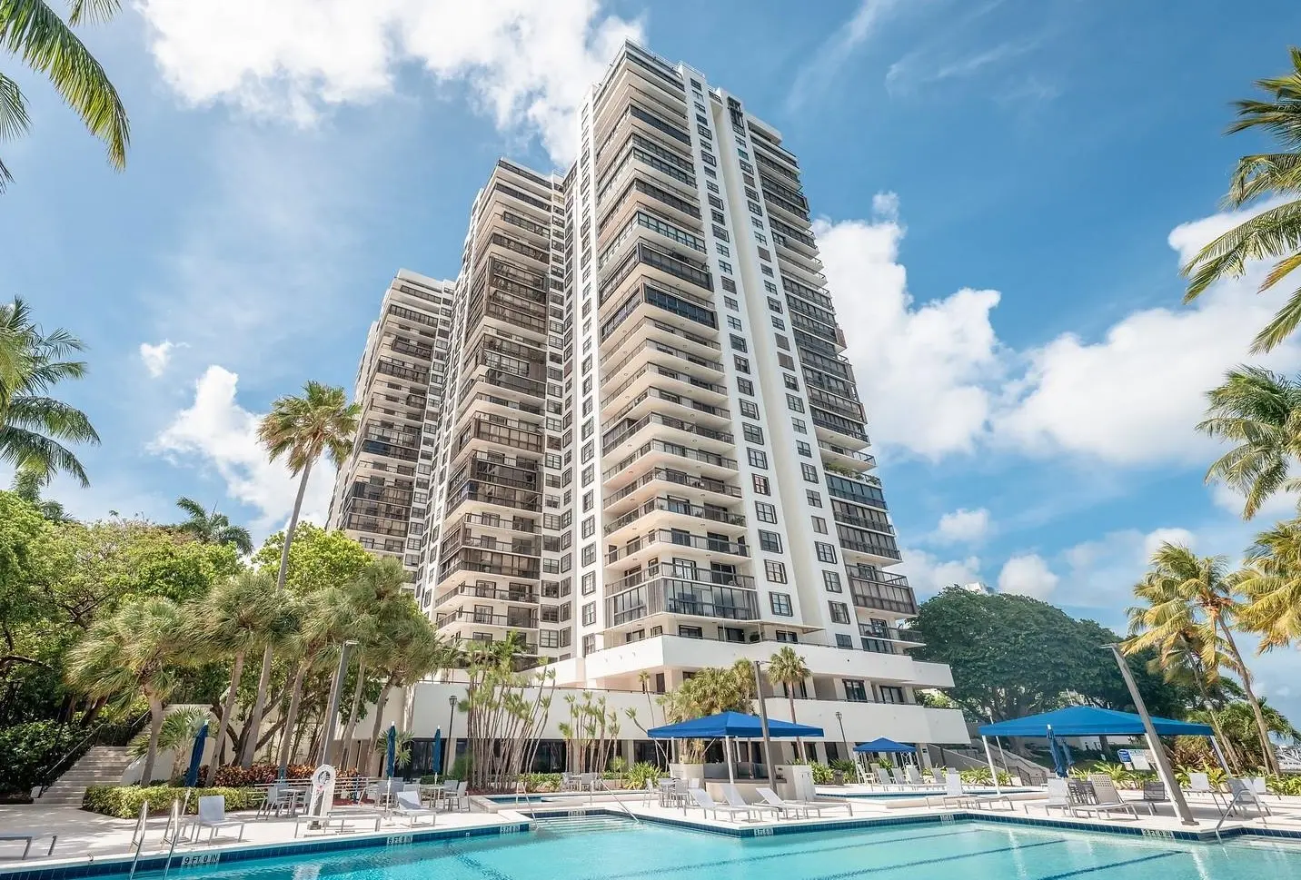 Elevated view of the Brickell Bay Club building with poolside area in Miami.