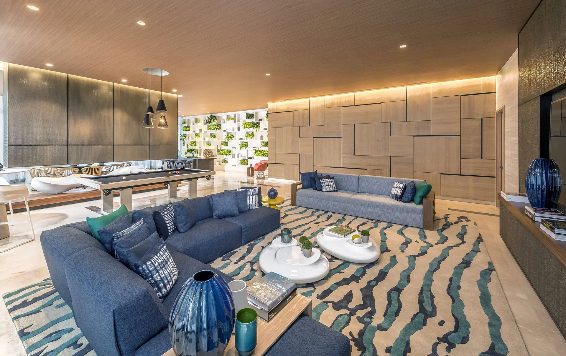 Contemporary lounge with blue sofas and geometric wood walls at Brickell Heights East.