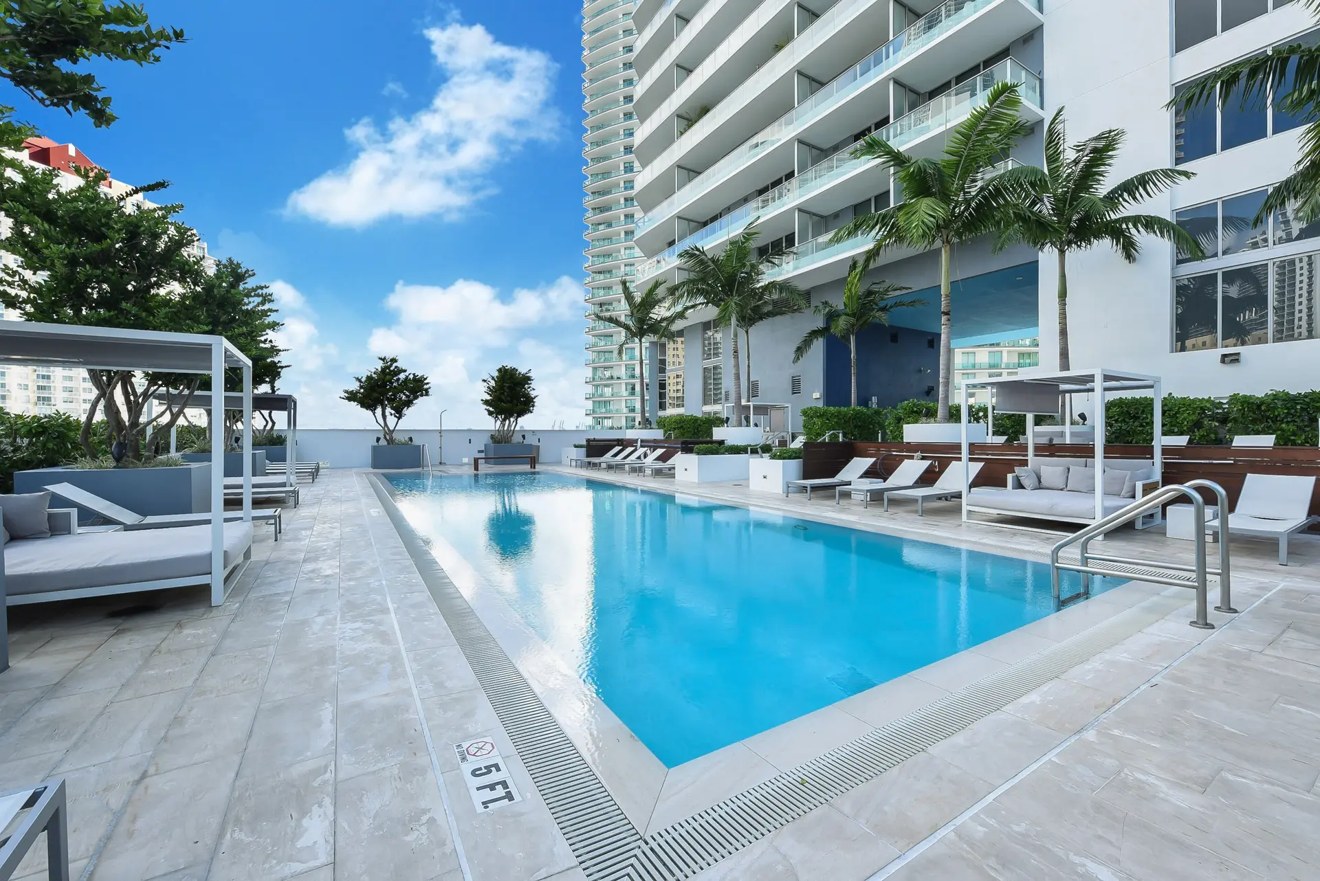 Brickell House showcases a luxurious pool area with lounge chairs and cabanas.