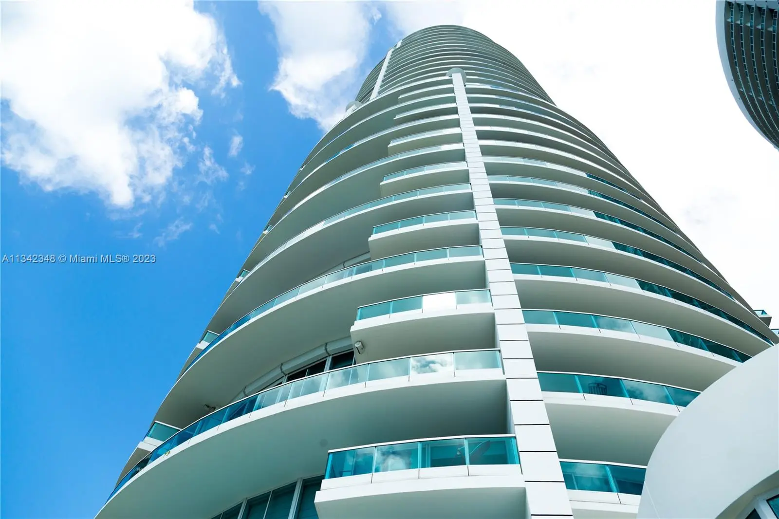 Upward view of modern architecture at Bristol Tower in Miami against a blue sky.
