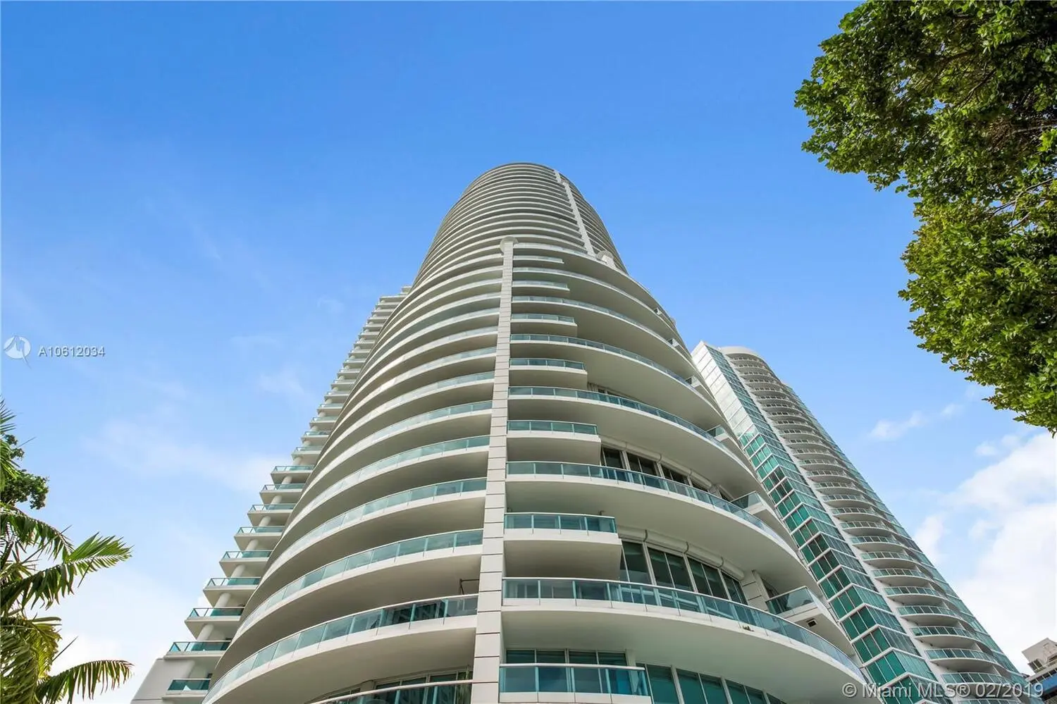 Bristol Tower's sleek exterior and curved balconies against a bright Miami sky.