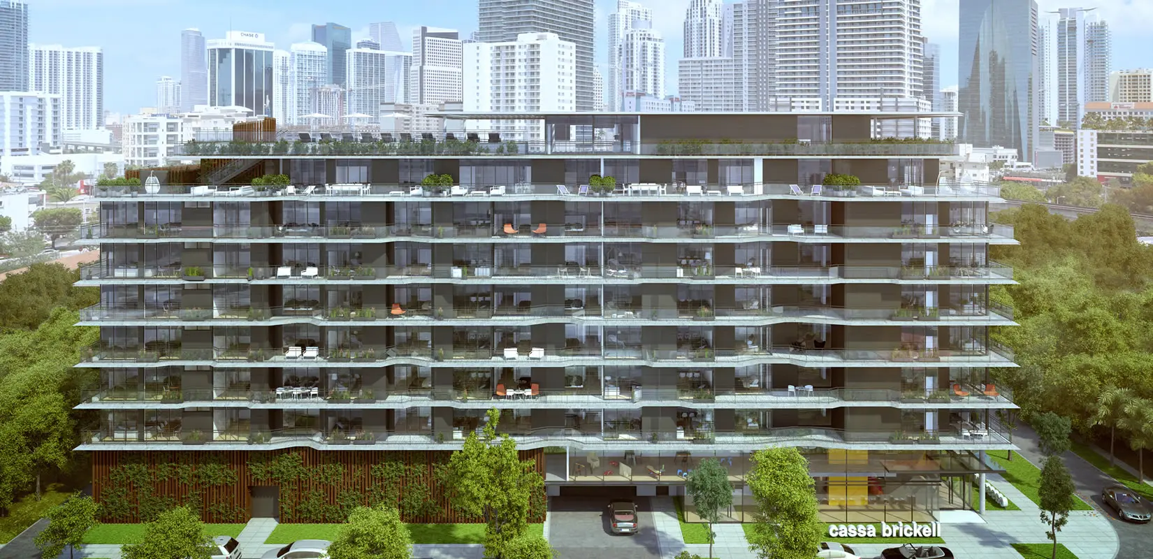 Cassa Brickell building exterior with lush greenery and Miami skyline.