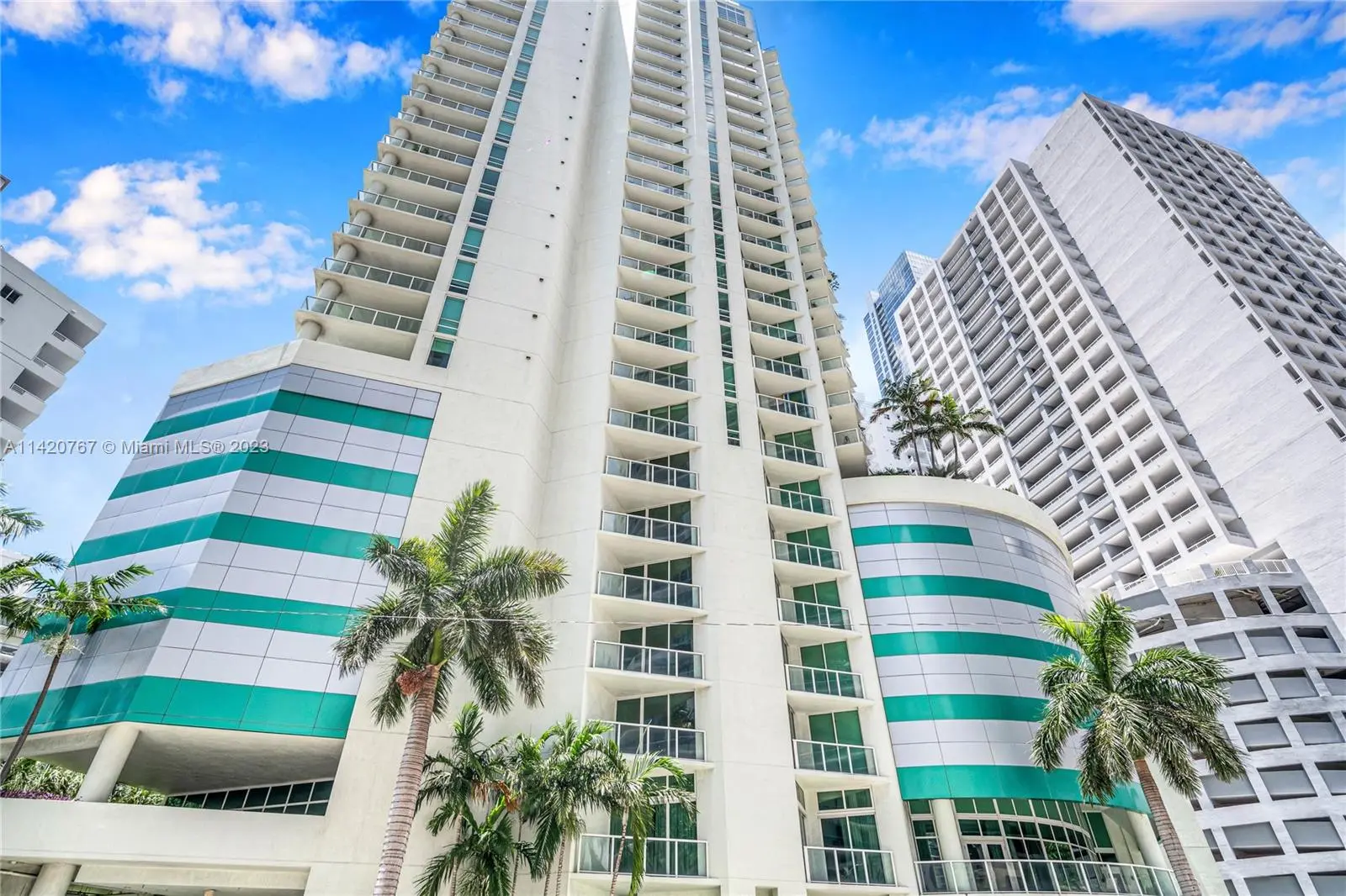 Emerald at Brickell with sleek glass balconies and green accents.