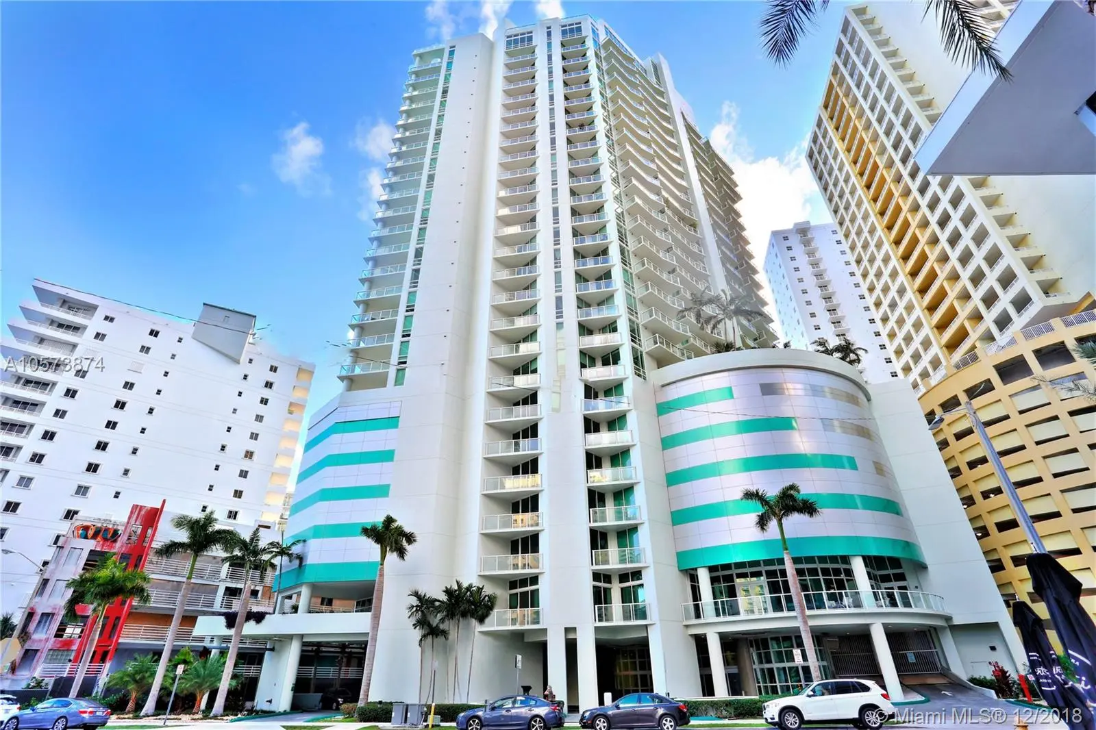 Emerald at Brickell showcasing its modern high-rise facade with palm trees in Miami.