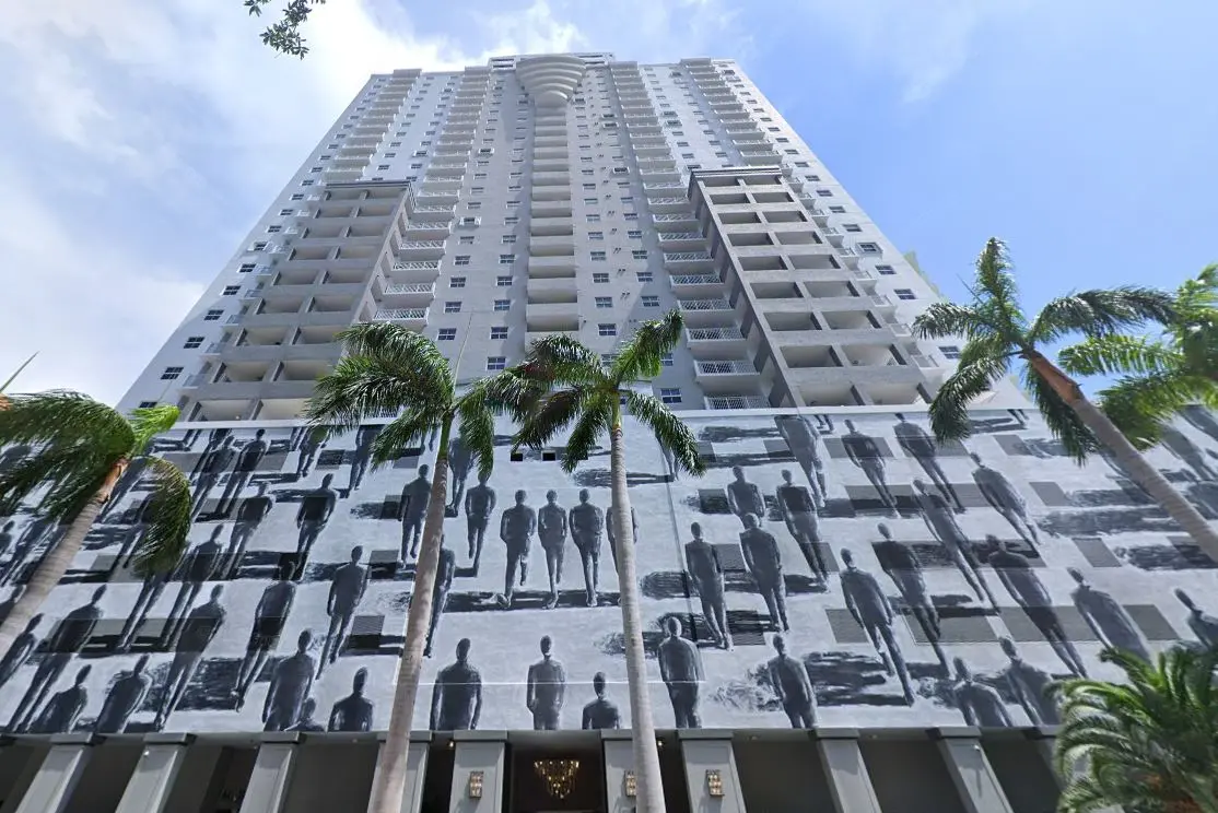 Fortune House Miami building exterior with palm trees and artistic facade.
