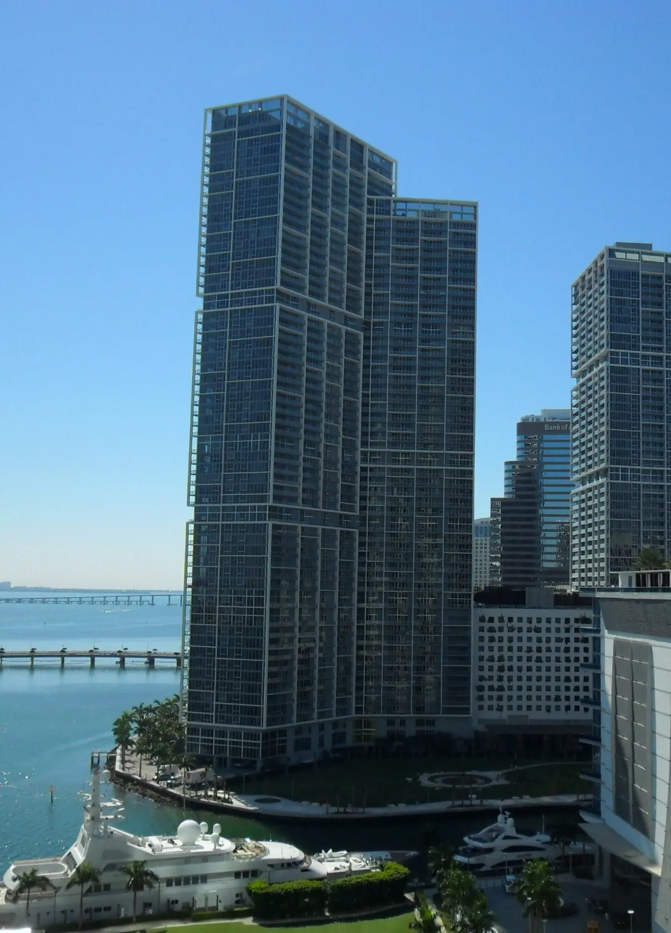 Icon Brickell I towers alongside Miami's waterfront with yachts docked nearby.