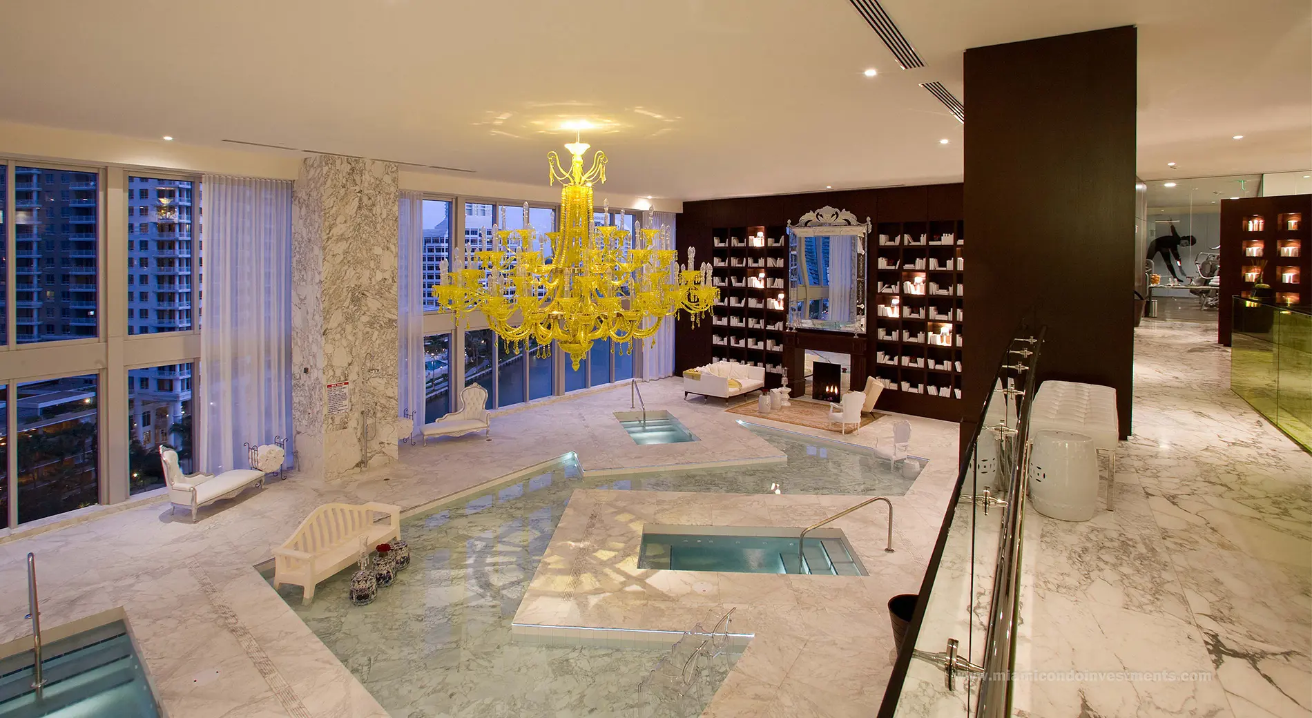 Icon Brickell II features a luxurious marble interior with a pool and bright yellow chandelier.