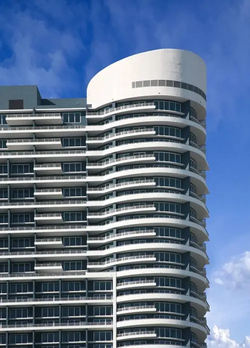 Infinity at Brickell features a curved facade with multiple balconies against a blue sky.