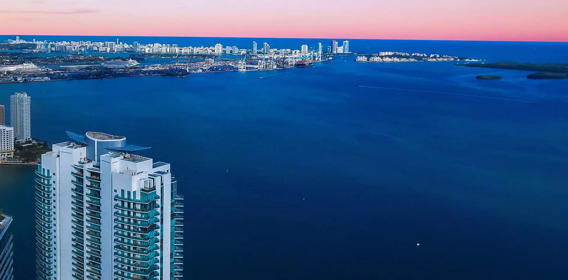 Jade at Brickell Bay overlooking the ocean with a sunset sky.