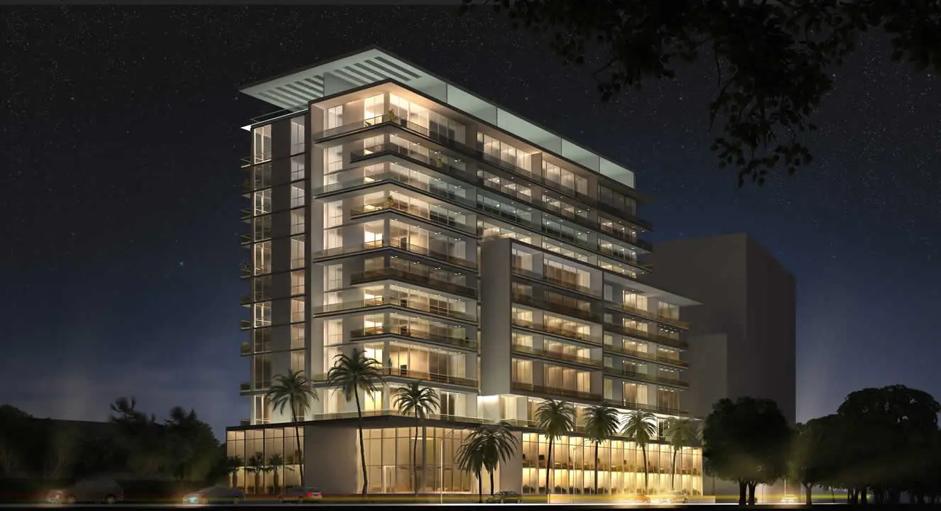 Night view of Le Parc at Brickell's illuminated exterior with palm trees.