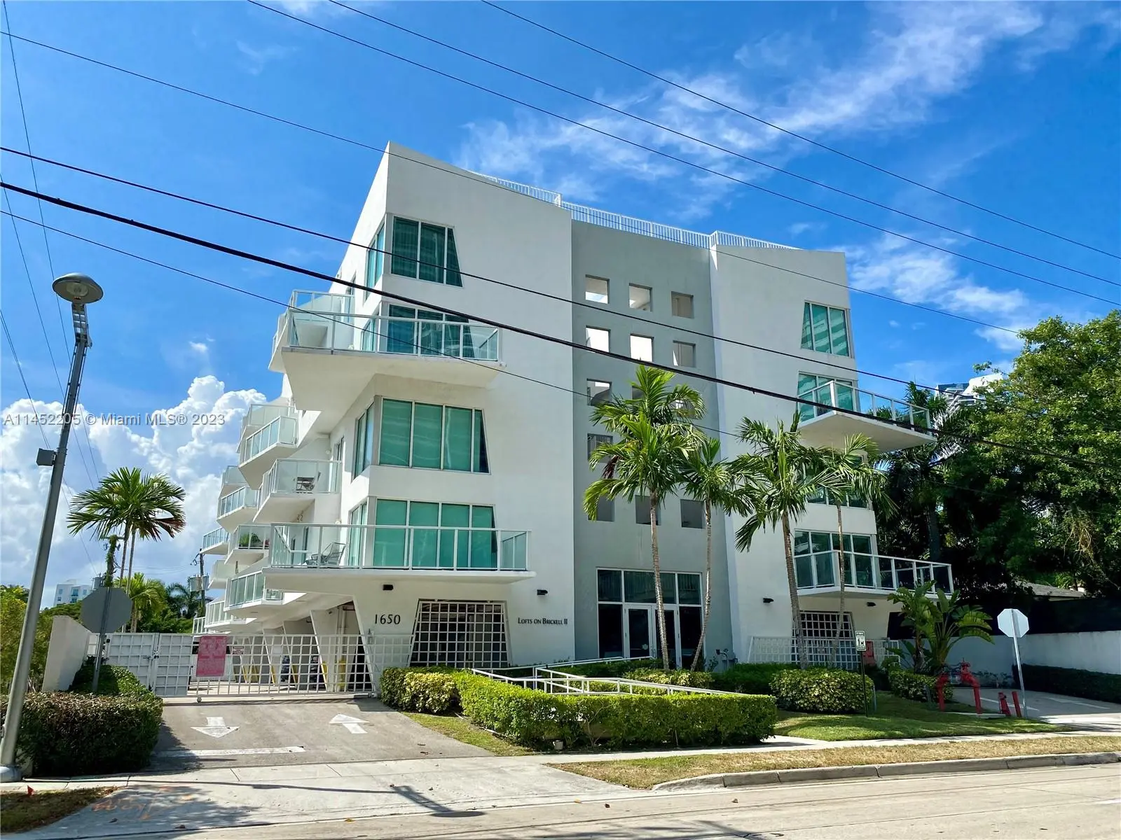 Lofts on Brickell Two modern condominium building with glass balconies and palm trees.
