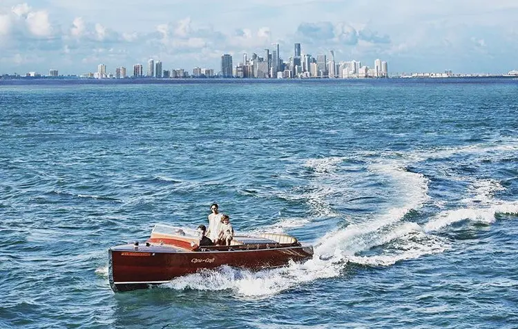 Boat cruising near Miami skyline for Miami Luxury Real Estate.