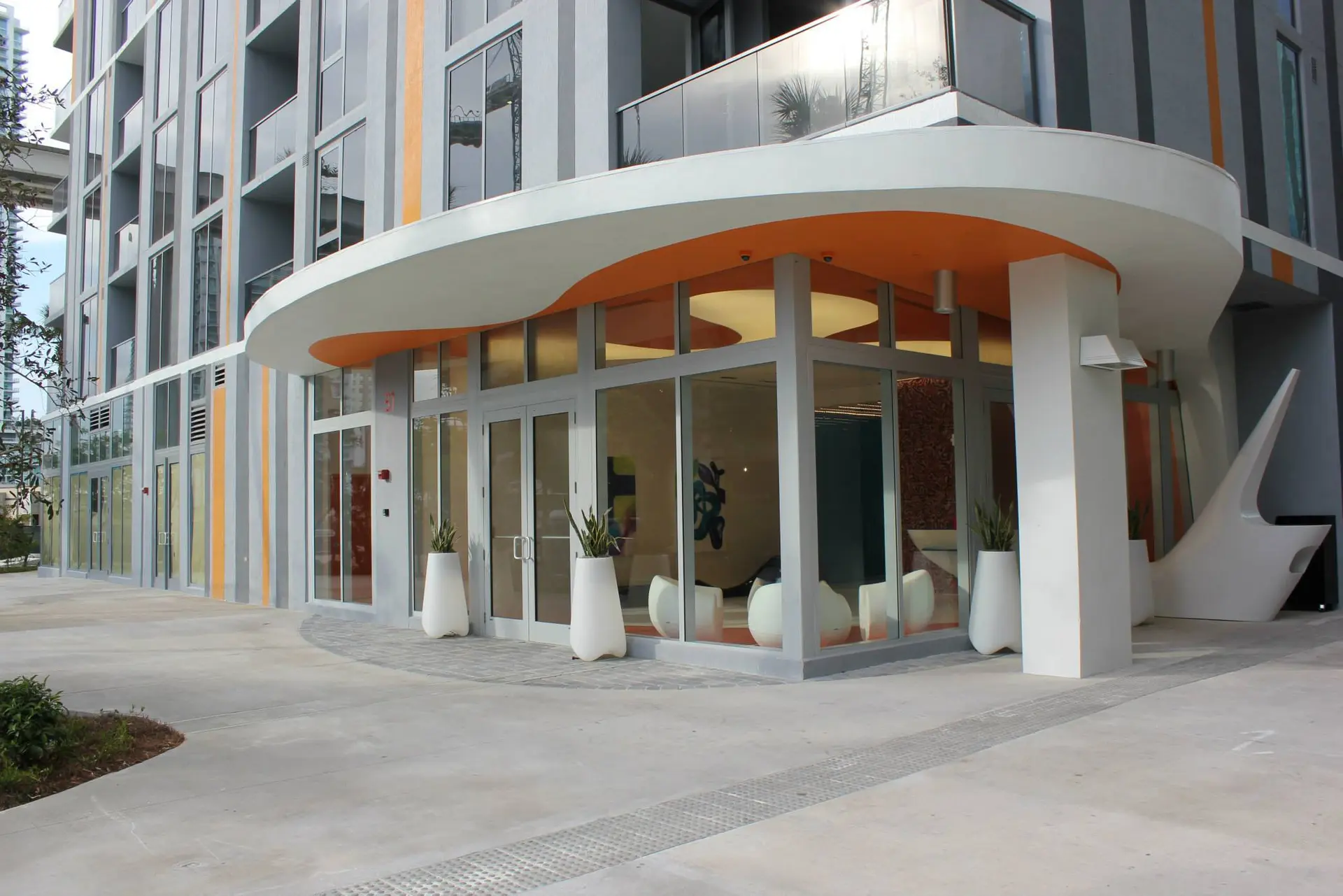 Modern entrance of the MyBrickell building in Miami featuring curved architecture.