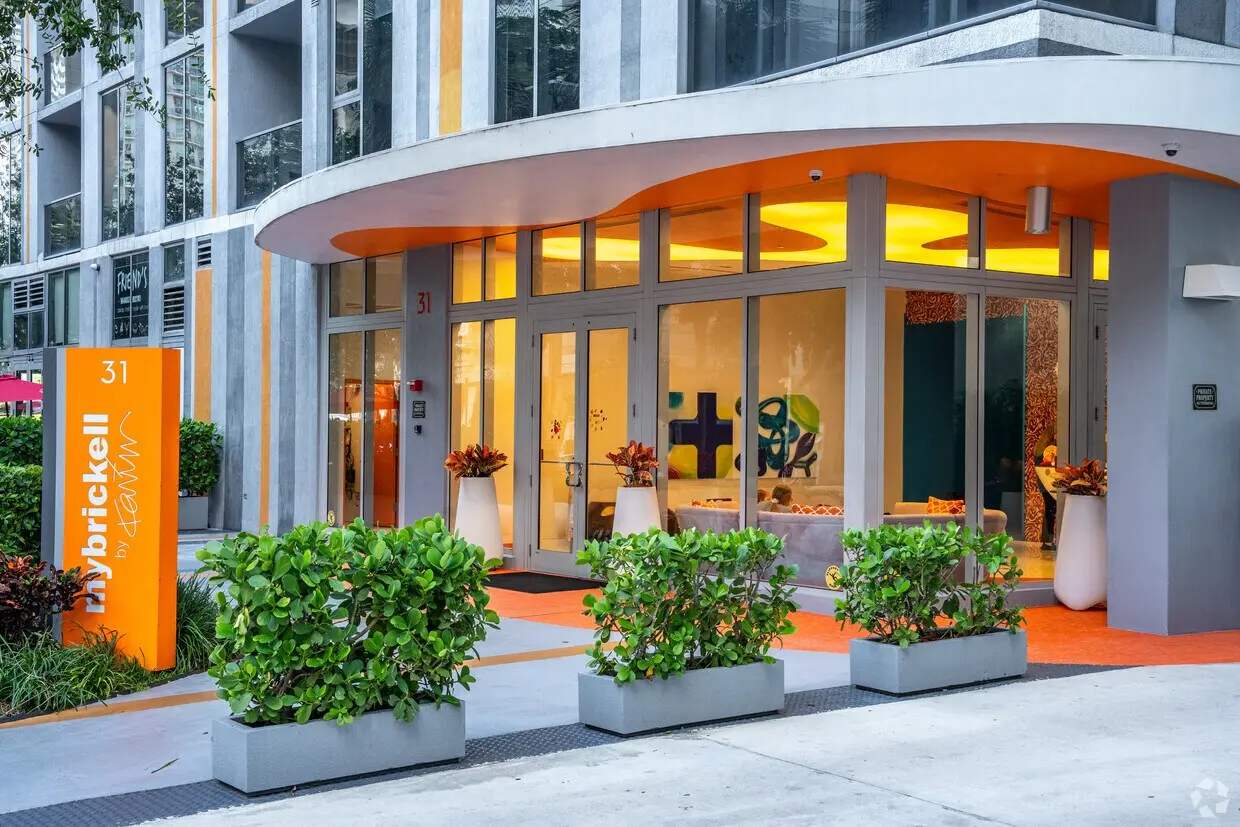 MyBrickell entrance with modern glass doors and vibrant orange accents in Miami.
