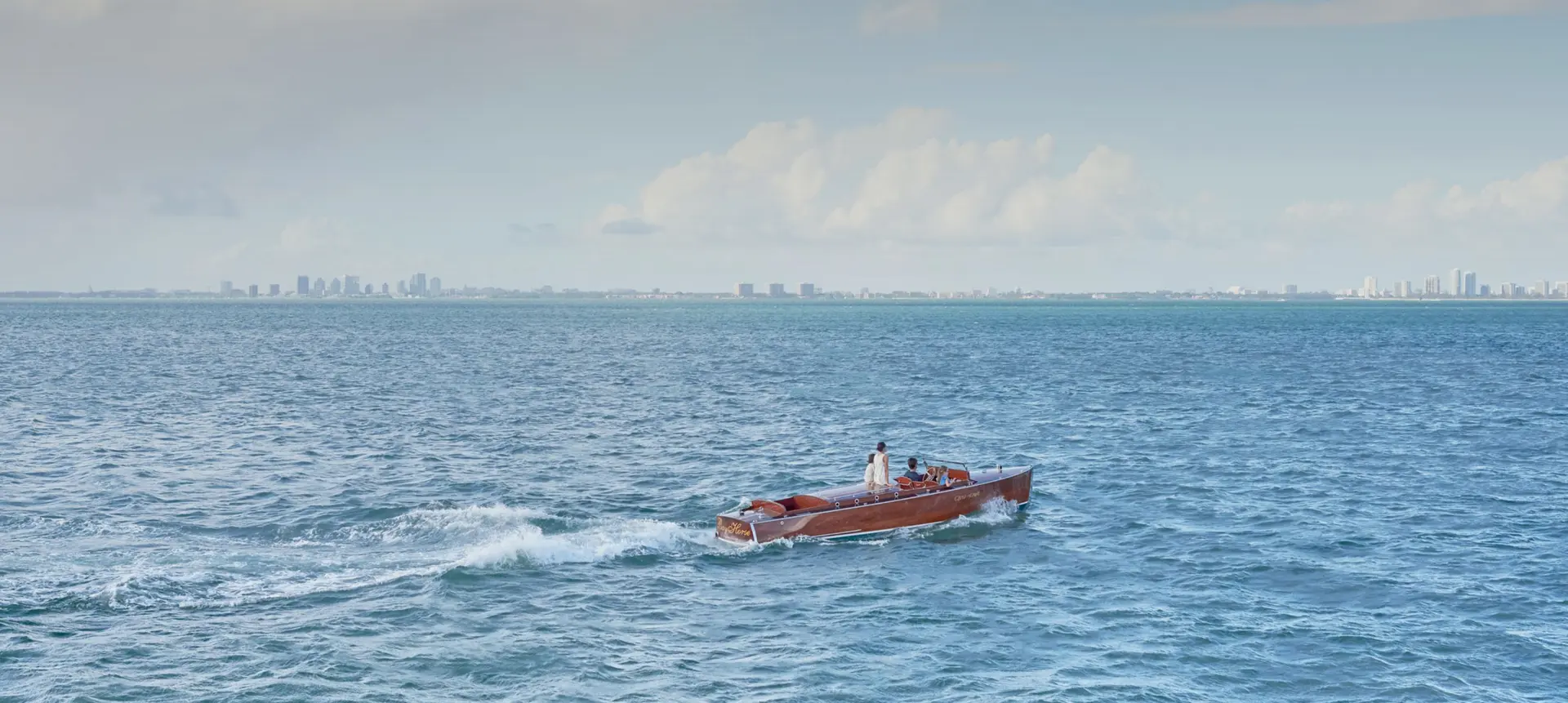 Luxury boat cruising through the ocean with a Miami skyline backdrop for Ocean Vista.