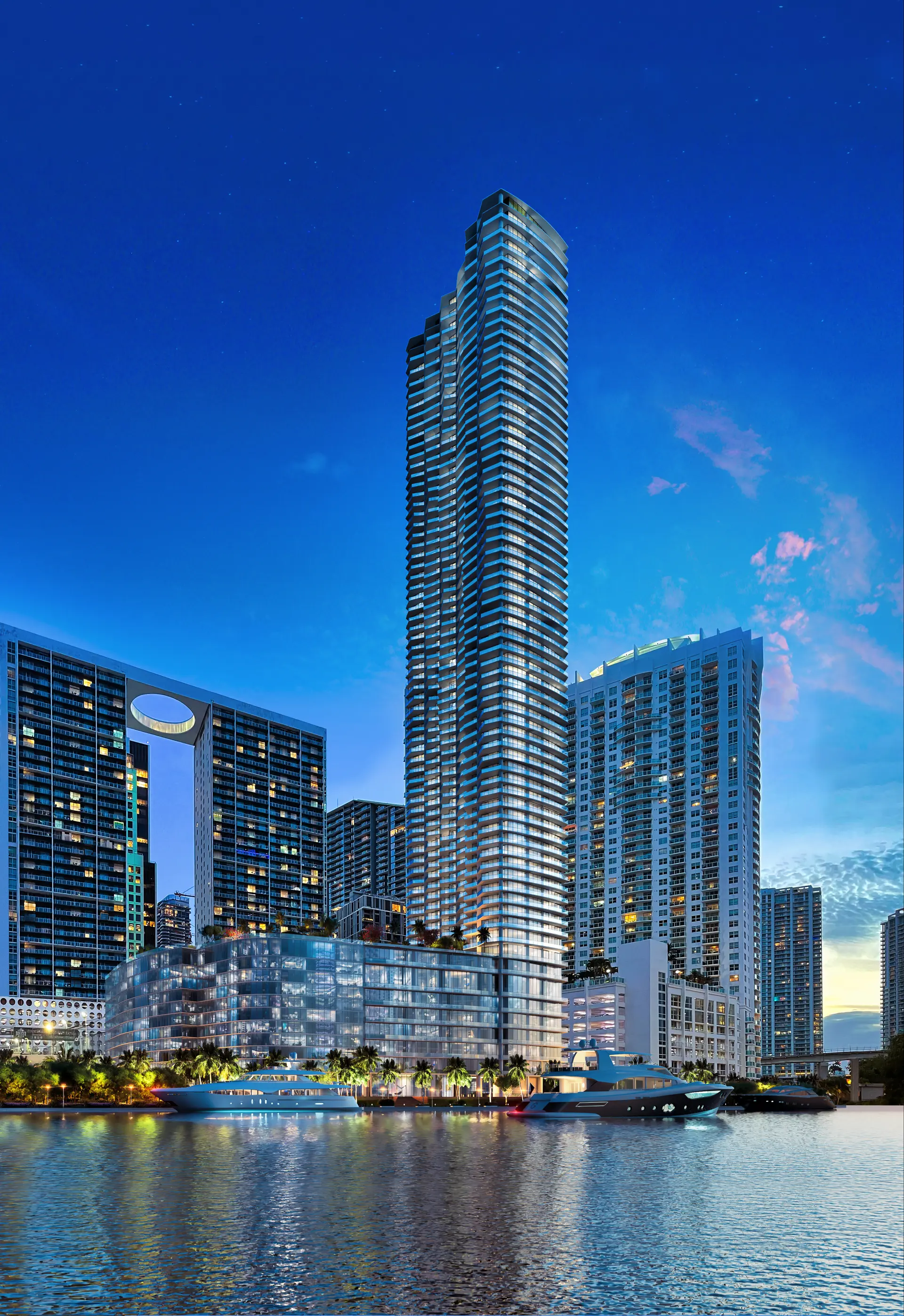 Project Name luxury tower in Miami at dusk by waterfront.