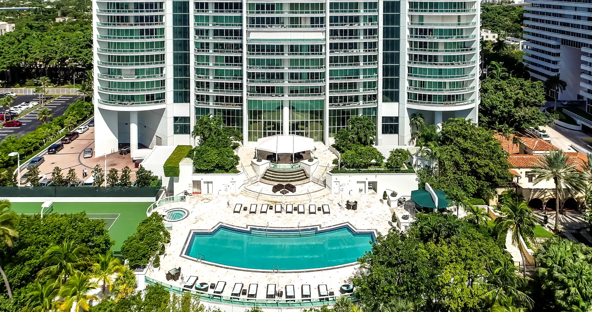 Santa Maria luxury condominium featuring a large pool and lush landscaping in Miami.