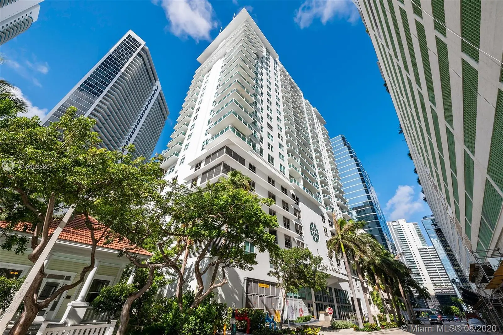 Solaris at Brickell high-rise in Miami against a blue sky with surrounding buildings.