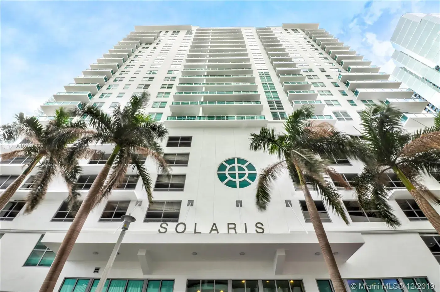 Palm trees and modern facade of Solaris at Brickell.