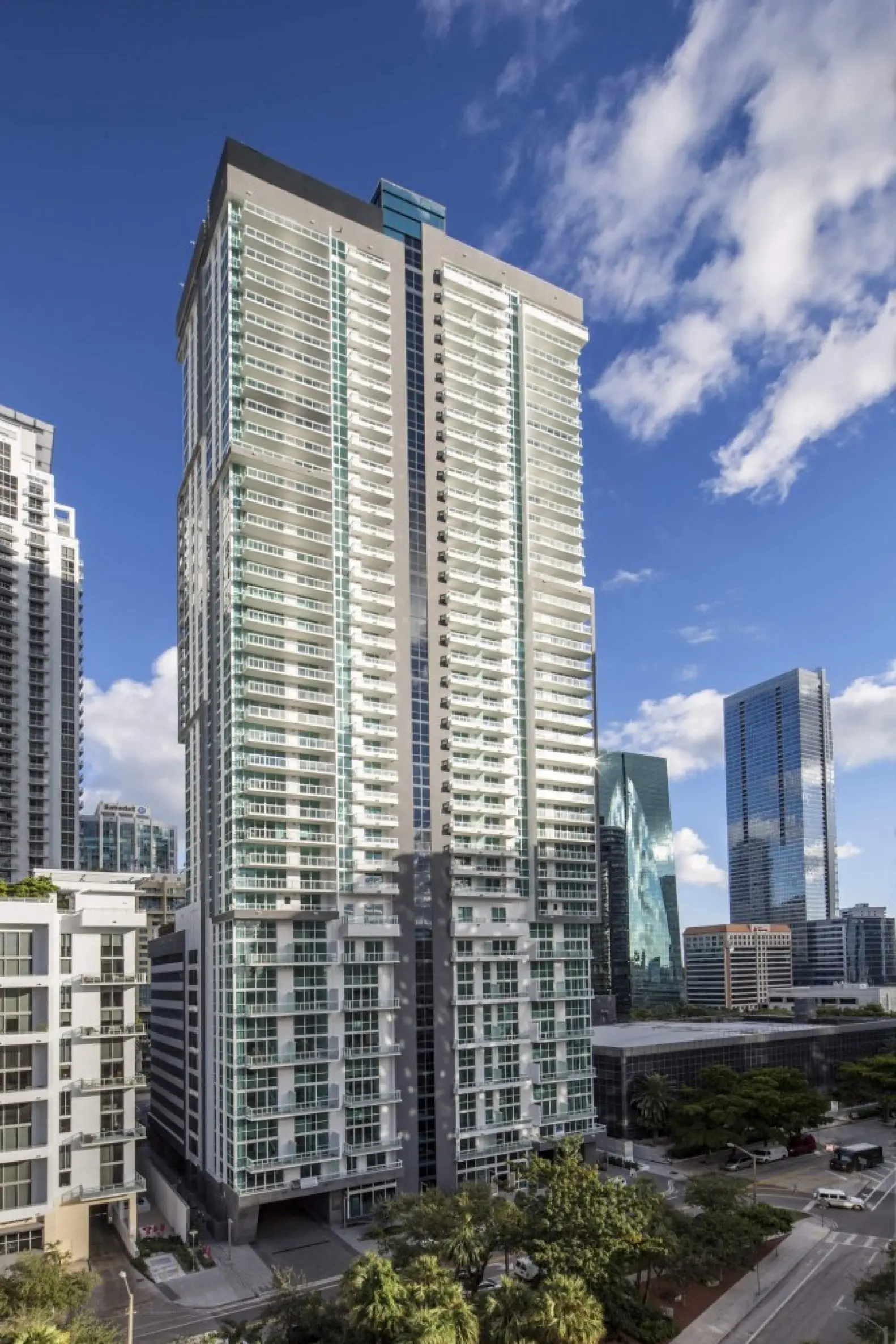 The Bond on Brickell modern high-rise in Miami with a clear blue sky backdrop.