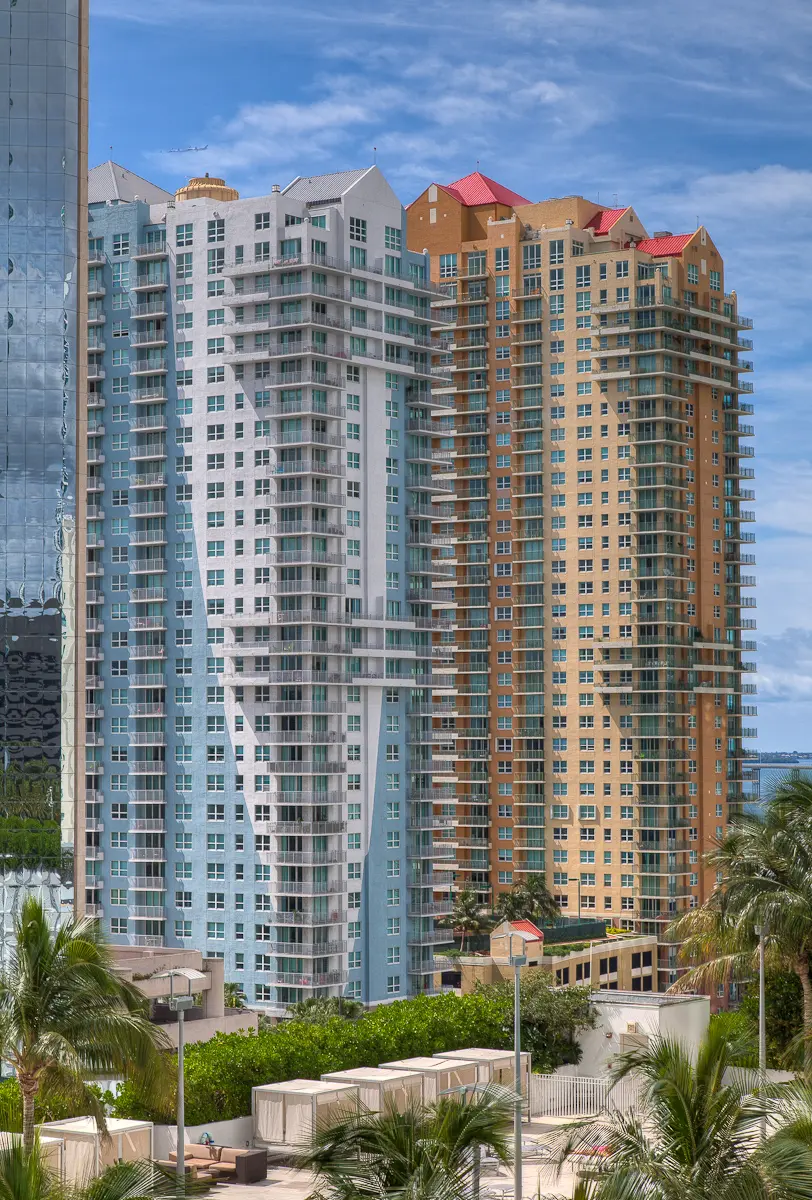 High-rise residential towers of The Mark on Brickell with blue skies and lush greenery.