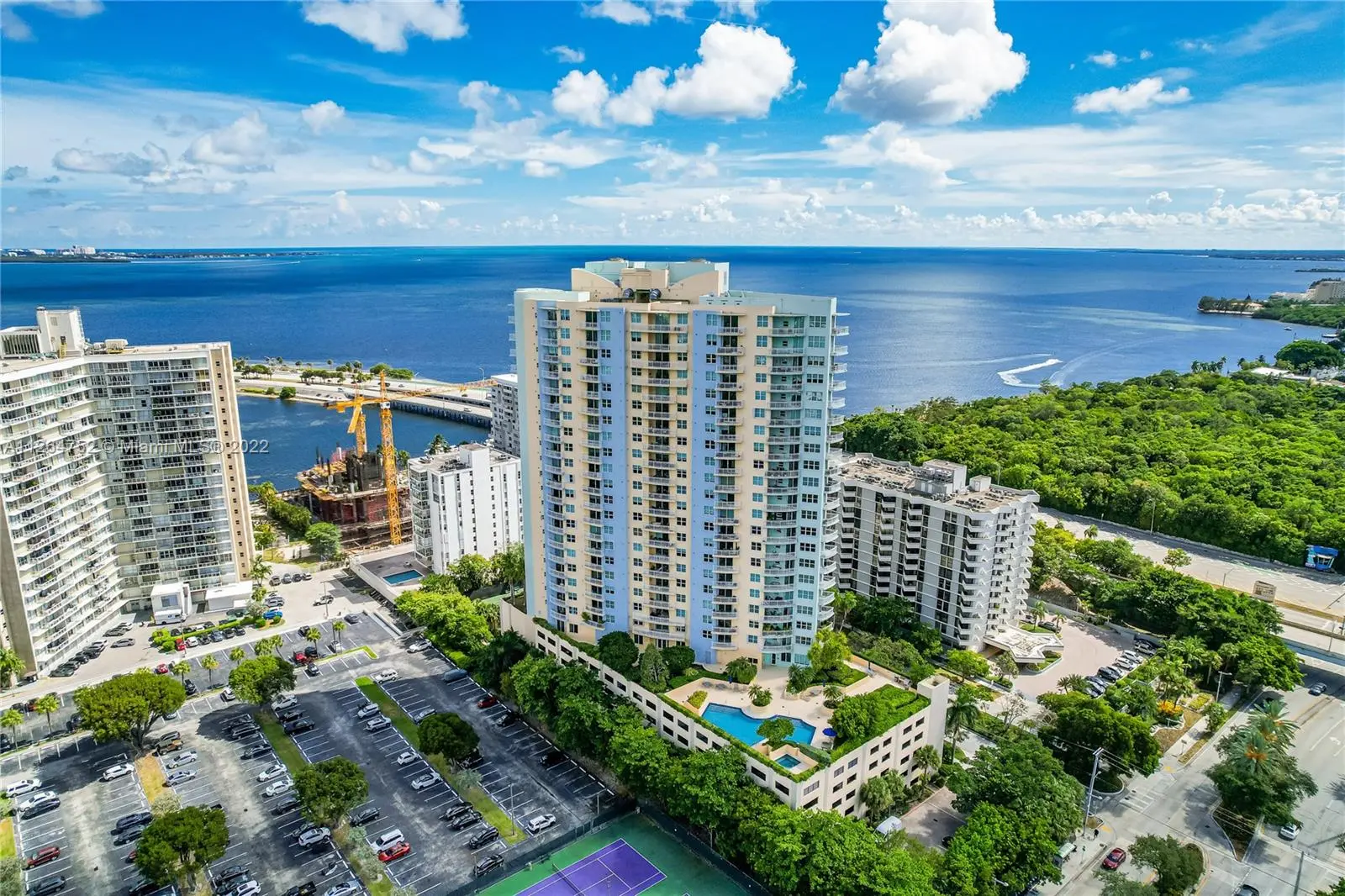Aerial view of The Metropolitan building in Miami with ocean view and greenery.