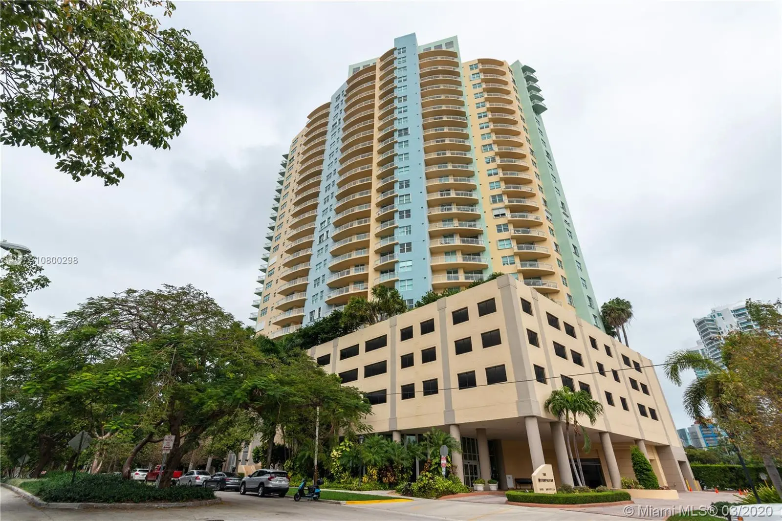 The Metropolitan tower rises over lush greenery in Miami.