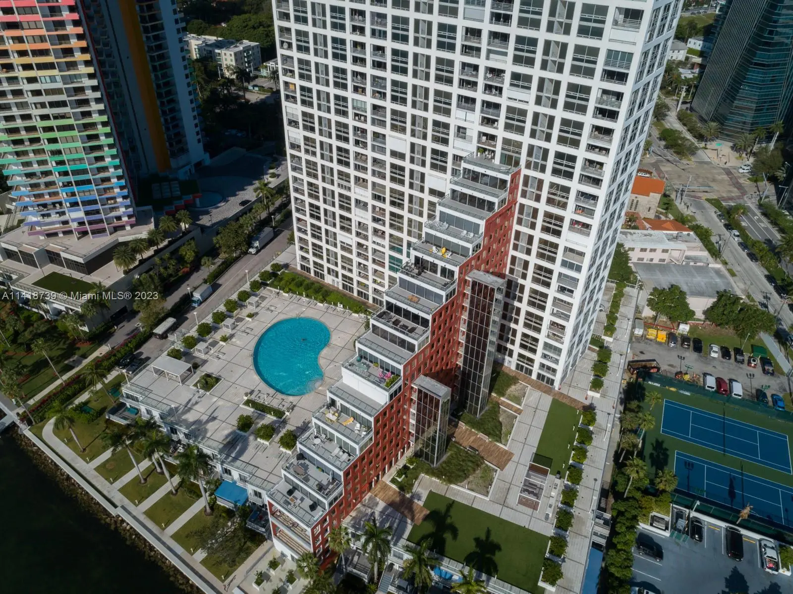 Aerial view of The Palace luxury building with pool and tennis court in Miami.
