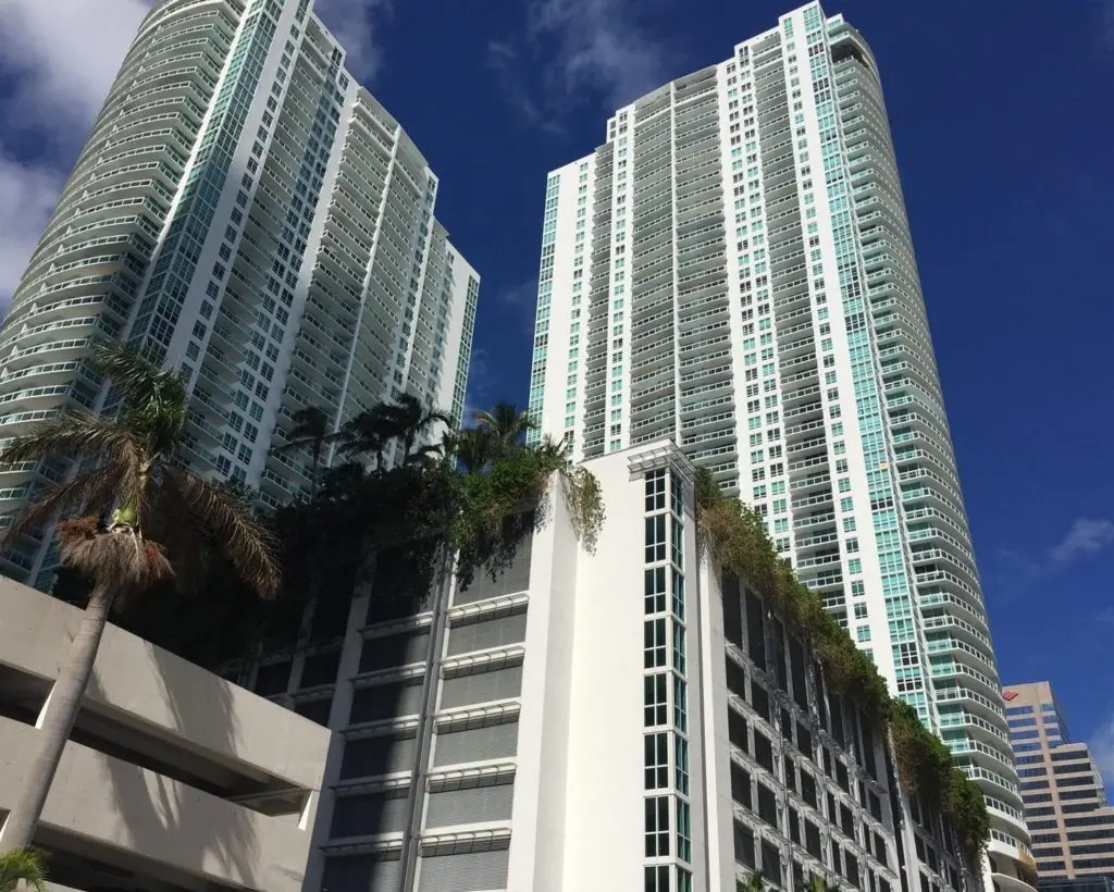 The Plaza on Brickell West high-rise towers in Miami with greenery at the base.