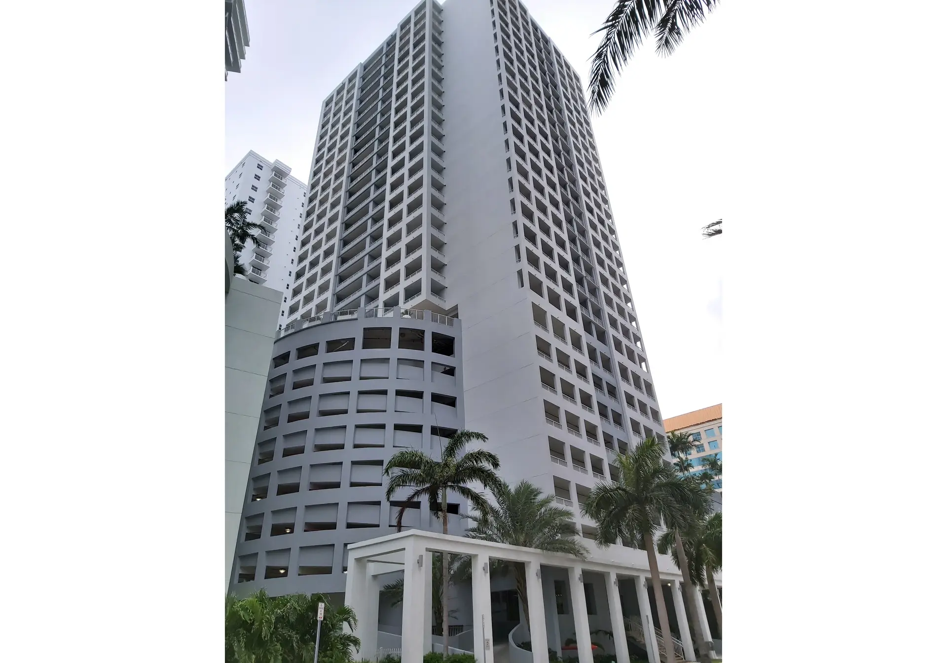 The Sail project showcases a modern high-rise building with palm trees in Miami.