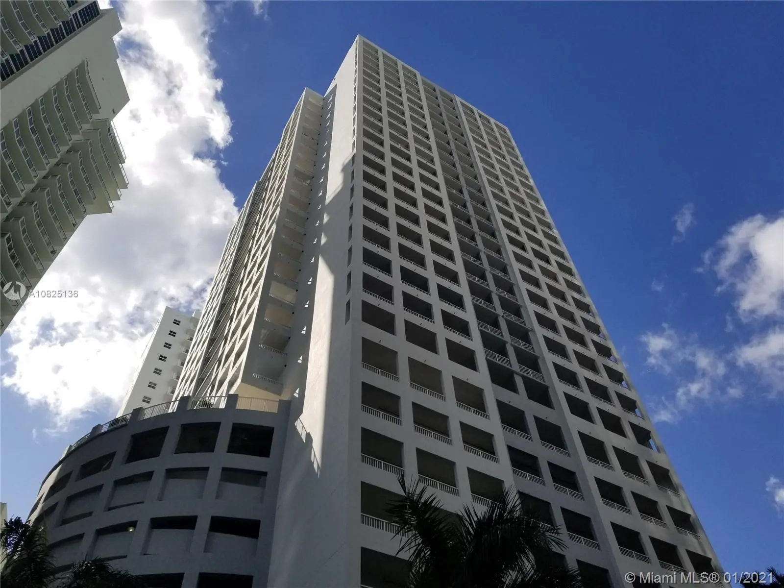 Exterior view of The Sail residential tower against a blue Miami sky.