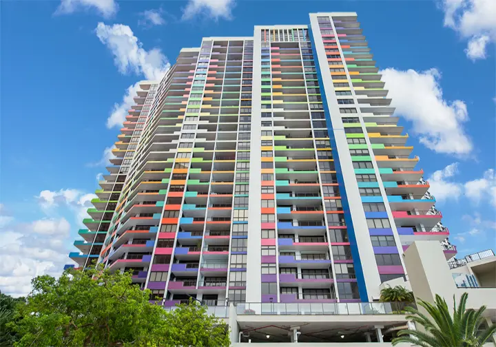 Villa Regina in Miami features vibrant multicolored balconies against a blue sky.